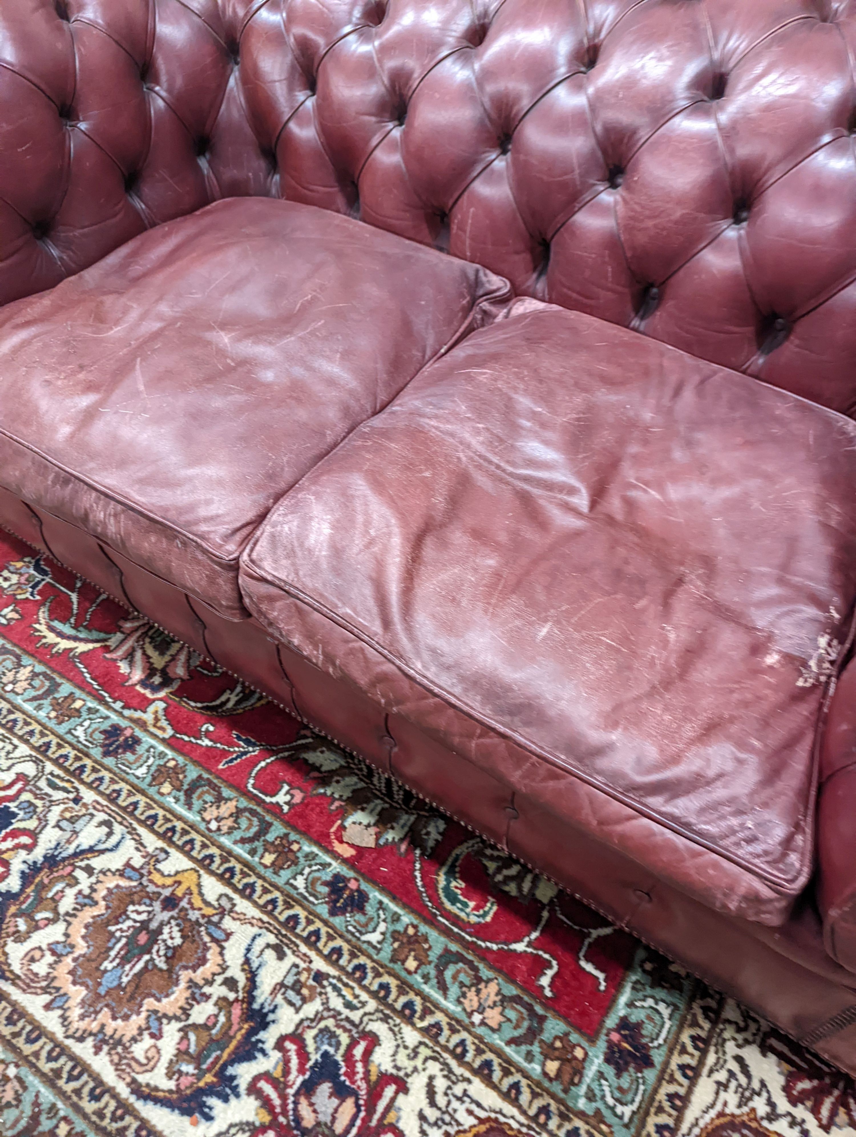 A Victorian style buttoned burgundy leather Chesterfield settee, length 172cm, depth 90cm, height 73cm
